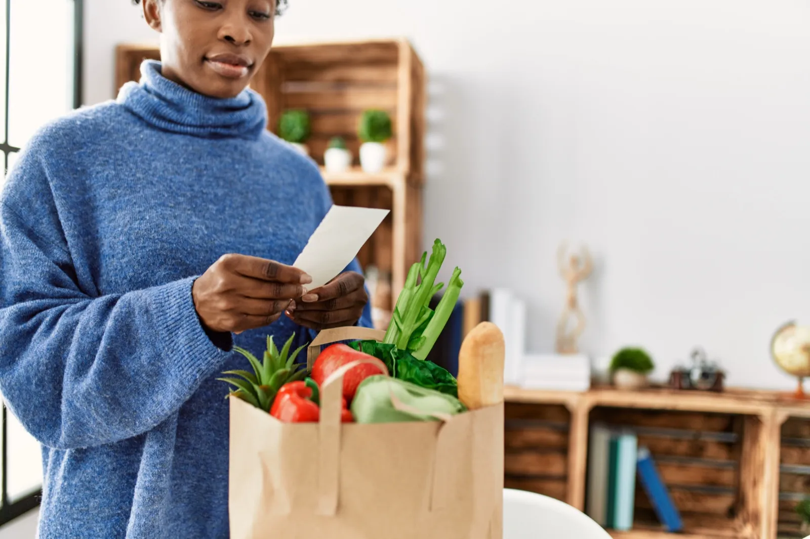 A woman reading a grocery receipt